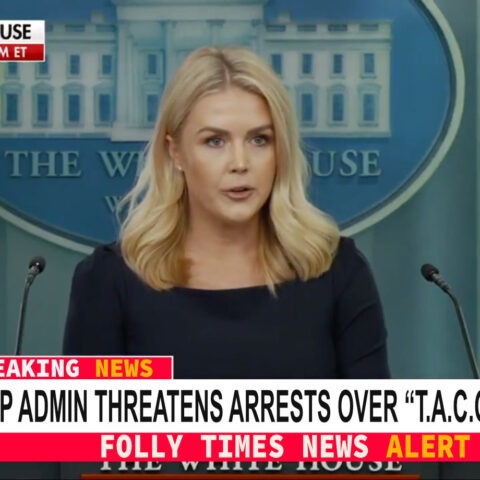 White House Press Secretary Karoline Leavitt speaks at a podium as a breaking news banner declares the Trump administration is threatening arrests over the “T.A.C.O.” nickname