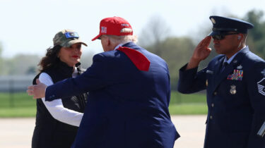President Trump greets Michigan Governor Gretchen Whitmer while a military officer salutes, amid controversial pardon comments