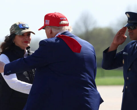 President Trump greets Michigan Governor Gretchen Whitmer while a military officer salutes, amid controversial pardon comments