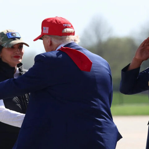 President Trump greets Michigan Governor Gretchen Whitmer while a military officer salutes, amid controversial pardon comments