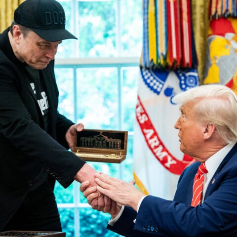 Donald Trump hands a ceremonial box to Elon Musk during a White House event