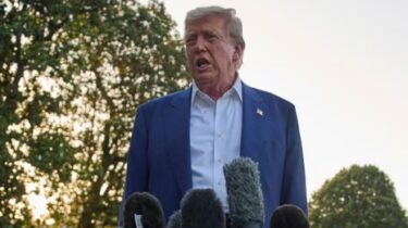 Donald Trump speaking outdoors in front of multiple microphones
