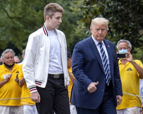 Barron Trump standing on White House steps with Donald Trump during press statement