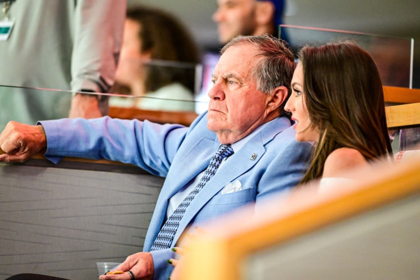 Bill Belichick and Jordon Hudson seated together, speaking privately
