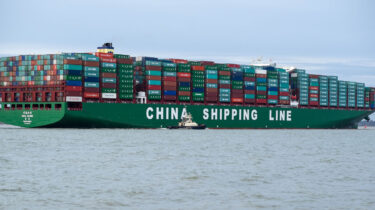 Massive China Shipping Line cargo ship entering U.S. port with hundreds of containers stacked on board