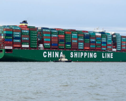 Massive China Shipping Line cargo ship entering U.S. port with hundreds of containers stacked on board