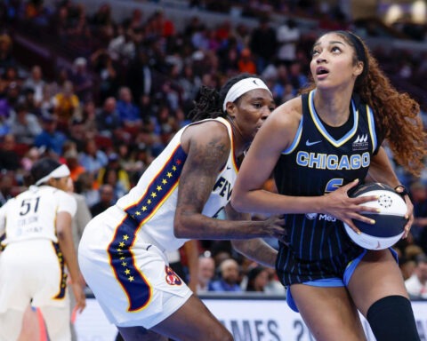 Chicago Sky forward Angel Reese holds the ball while being defended by an Indiana Fever player during a WNBA game