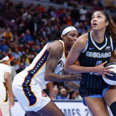 Chicago Sky forward Angel Reese holds the ball while being defended by an Indiana Fever player during a WNBA game