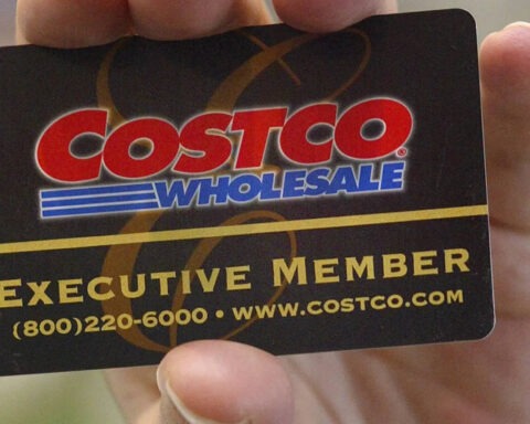 Close-up of a hand holding a black Costco Executive Member card