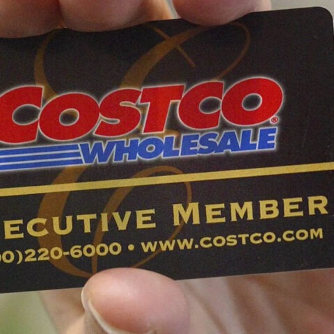 Close-up of a hand holding a black Costco Executive Member card