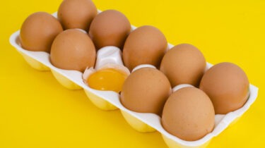 brown eggs with one egg cracked open in the center