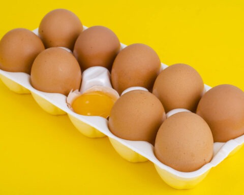 brown eggs with one egg cracked open in the center