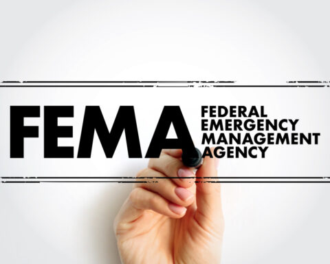 Hand underlining the FEMA logo, which stands for Federal Emergency Management Agency
