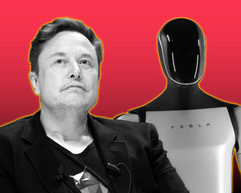 Elon Musk sitting beside Tesla’s humanoid Optimus robot against a red background.