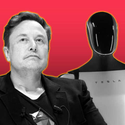Elon Musk sitting beside Tesla’s humanoid Optimus robot against a red background.