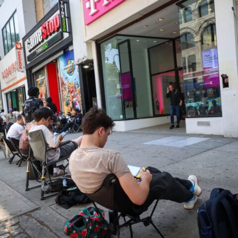 Gamers waiting in a long line outside GameStop and T-Mobile stores in lawn chairs during the Nintendo Switch 2 release.