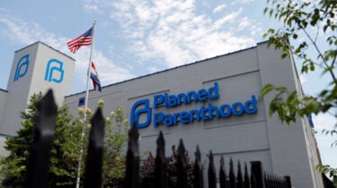 Protesters holding signs in support of Planned Parenthood outside a government building