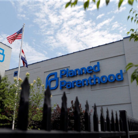 Protesters holding signs in support of Planned Parenthood outside a government building