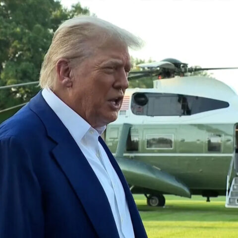Donald Trump speaking outdoors in front of multiple microphones