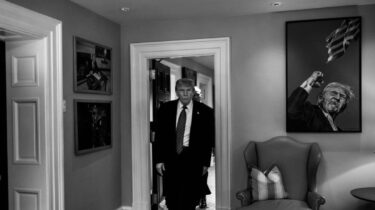Black and white photo of trump entering a room.
