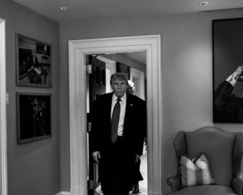 Black and white photo of trump entering a room.