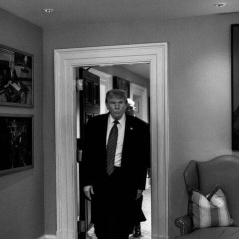 Black and white photo of trump entering a room.