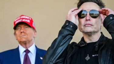 Donald Trump in a red MAGA hat stands behind Elon Musk adjusting his sunglasses, both facing forward with intense expressions.