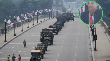 Military vehicles line an empty street for Trump’s birthday parade as Trump appears to nap during the event