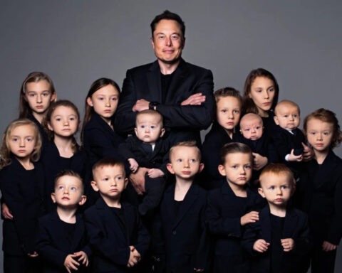 Elon Musk posing with large group of children wearing matching black outfits