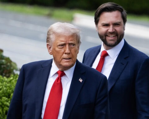 Donald Trump and JD Vance standing outside, both wearing red ties