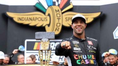 Bubba Wallace pointing with Brickyard 400 trophy after historic NASCAR win