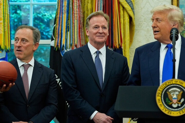 Trump in suit awkwardly holding a sports medal