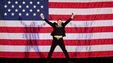 Elon Musk jumping in front of American flag during America Party launch