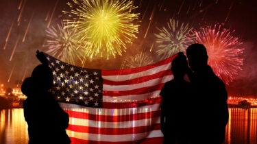 Shirtless suburban dad enjoying fireworks in backyard