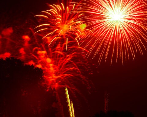 Fireworks exploding in a dry suburban neighborhood