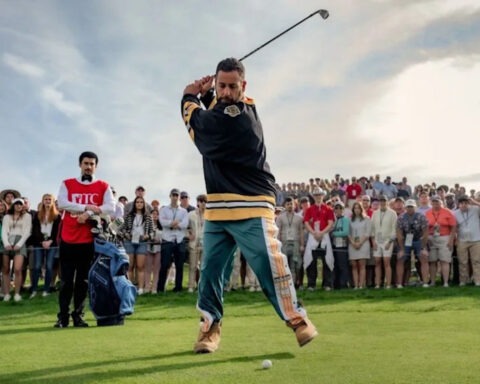 Adam Sandler mid-swing as Happy Gilmore on a crowded golf course