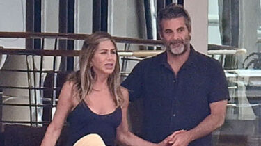 Jennifer Aniston and Jim Curtis holding hands aboard a luxury yacht