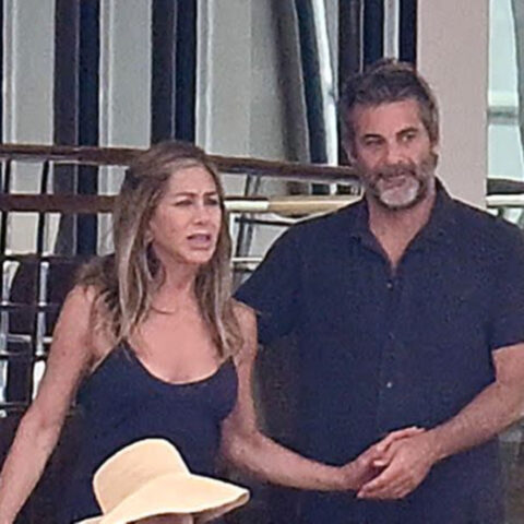 Jennifer Aniston and Jim Curtis holding hands aboard a luxury yacht