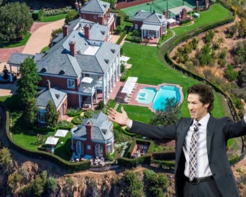 Joel Osteen smiling in front of his massive luxury mansion