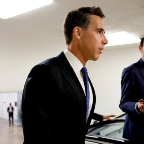 Senator Josh Hawley speaking to a reporter in a government hallway
