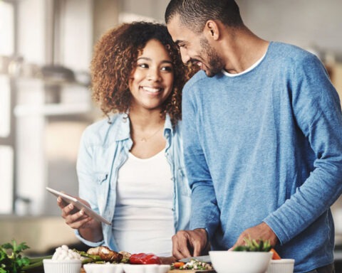 Couple smiling with a grocery cart full of store-brand goods
