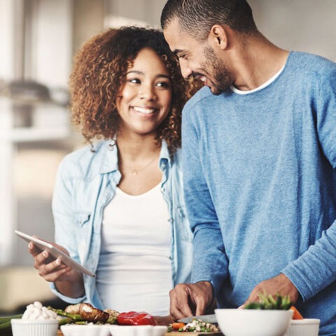 Couple smiling with a grocery cart full of store-brand goods