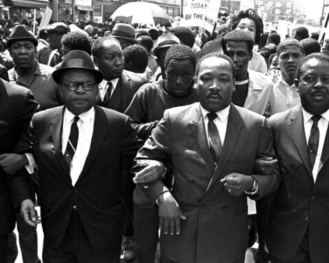 Martin Luther King Jr. marches arm-in-arm during the civil rights movement