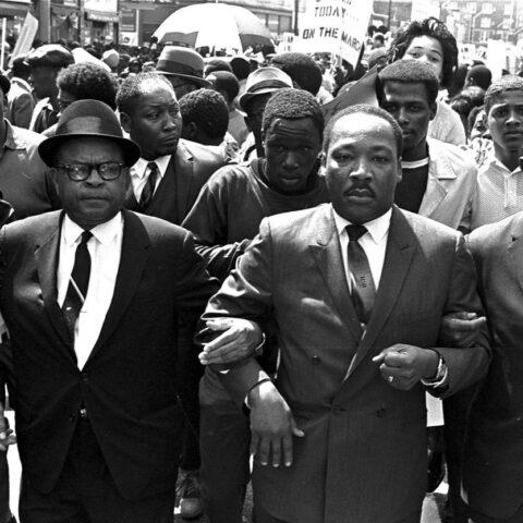 Martin Luther King Jr. marches arm-in-arm during the civil rights movement