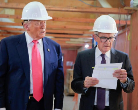 Donald Trump and Jerome Powell in hard hats at Federal Reserve construction site