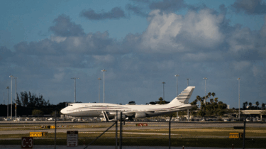 Donald Trump waving next to used Qatari Boeing jet intended as Air Force One
