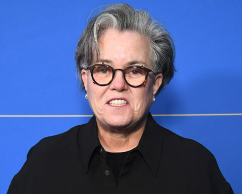 Rosie O'Donnell at press event with blue backdrop