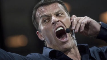 Tony Robbins yelling into headset microphone during motivational seminar