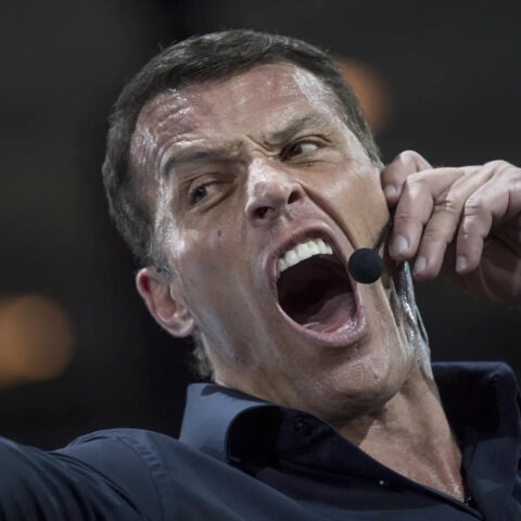 Tony Robbins yelling into headset microphone during motivational seminar