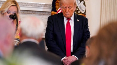 Donald Trump standing with eyes closed at White House prayer luncheon